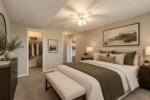 A bedroom with a large bed and a painting on the wall.
