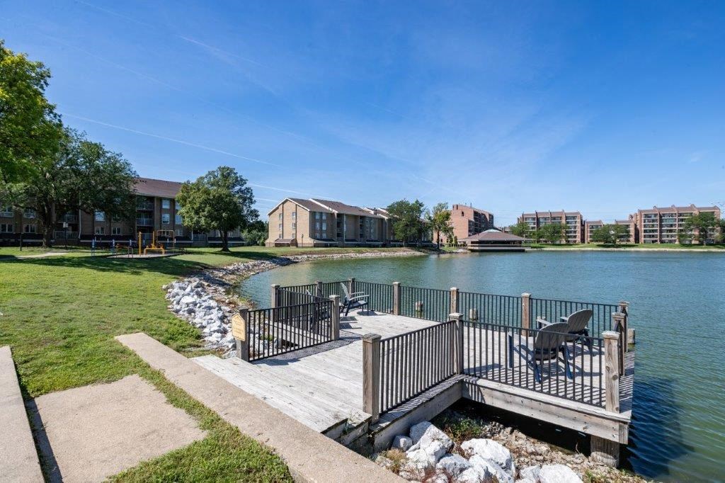 a dock on a lake with houses in the background
