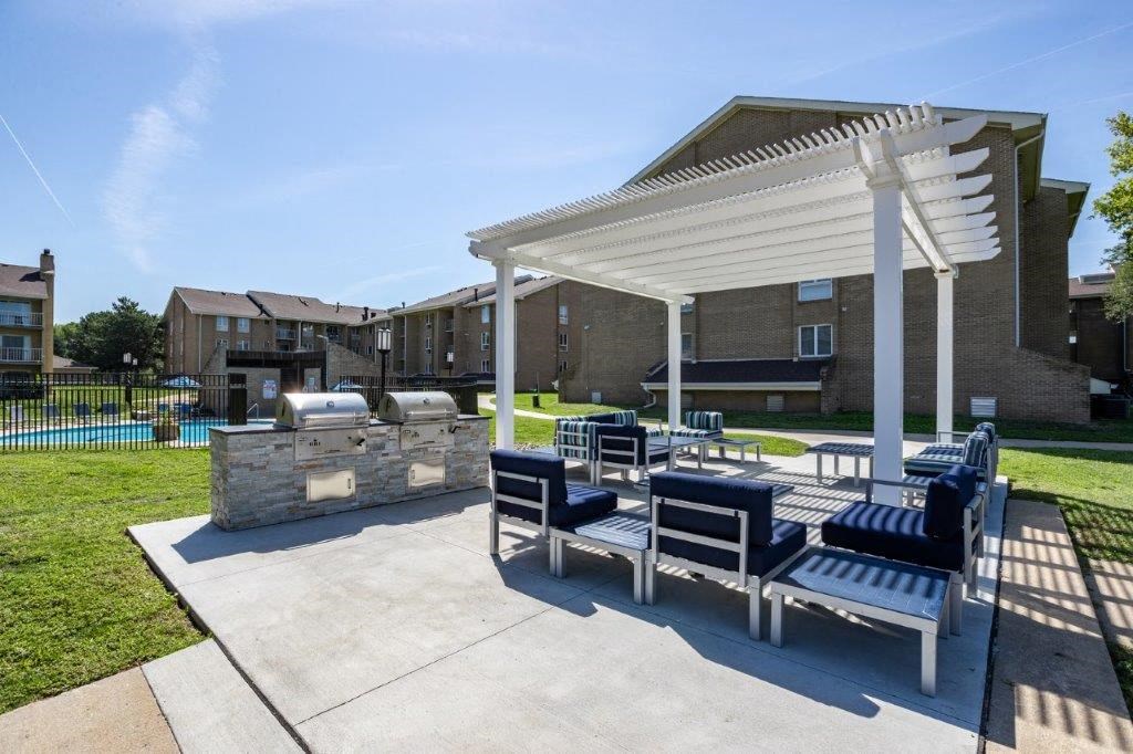 a patio with benches and a pavilion with a fire pit