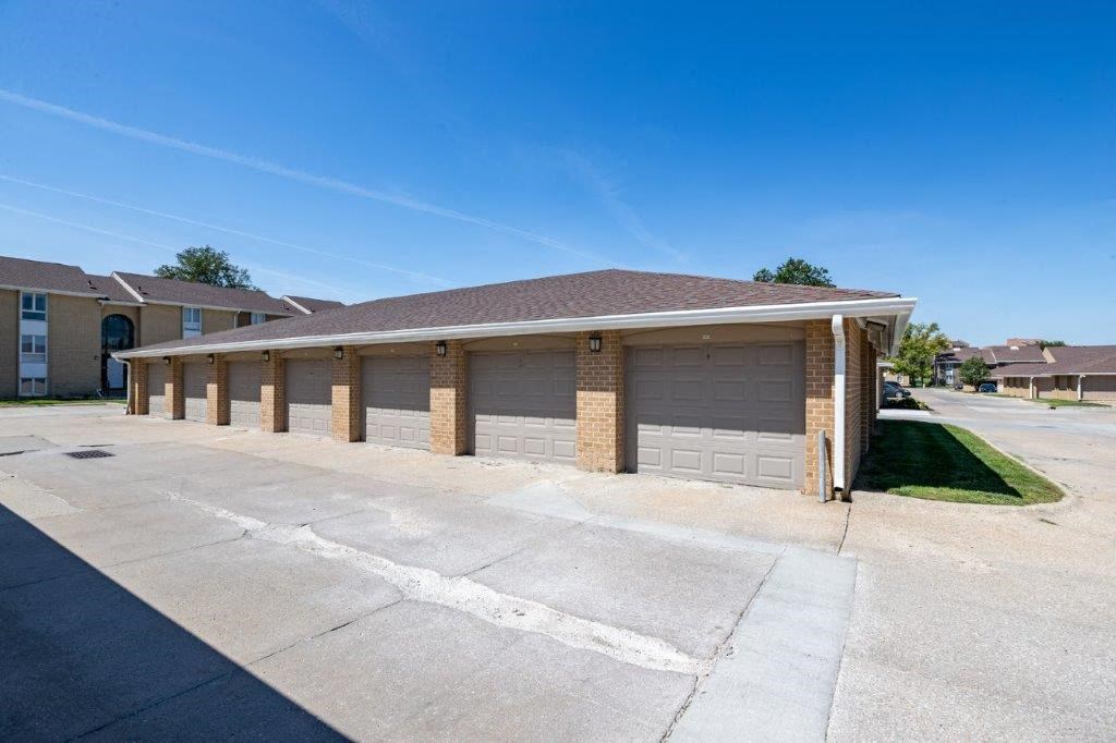 an empty parking lot in front of a building with garages