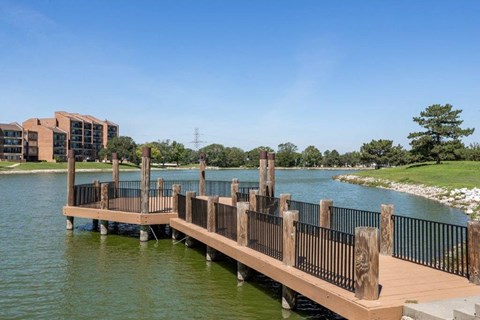 a dock over a body of water with a building in the background