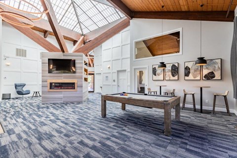 a large living room with a pool table and a fireplace