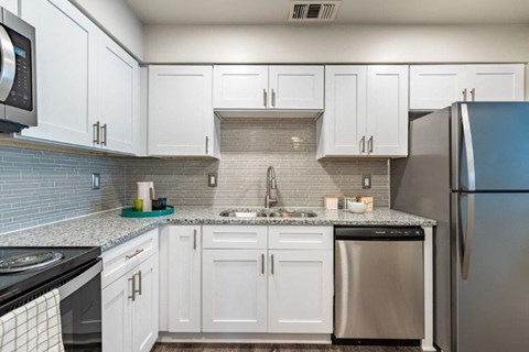 a kitchen with white cabinets and stainless steel appliances