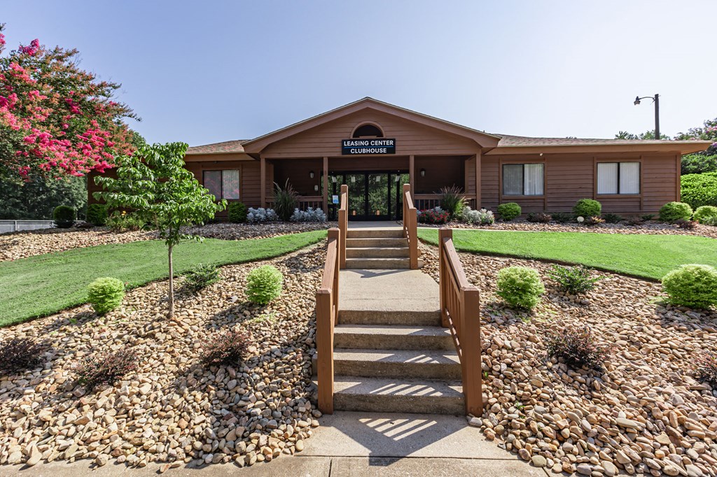a view of the front of a brown building with stairs and a sidewalk