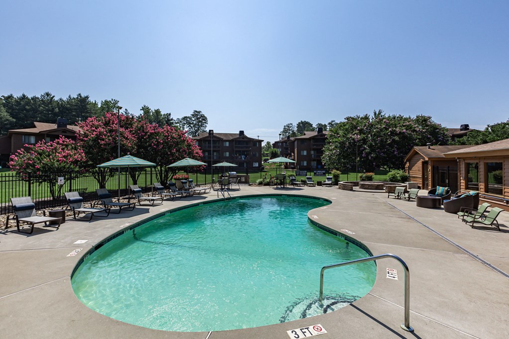 a swimming pool with chairs and umbrellas at the resort