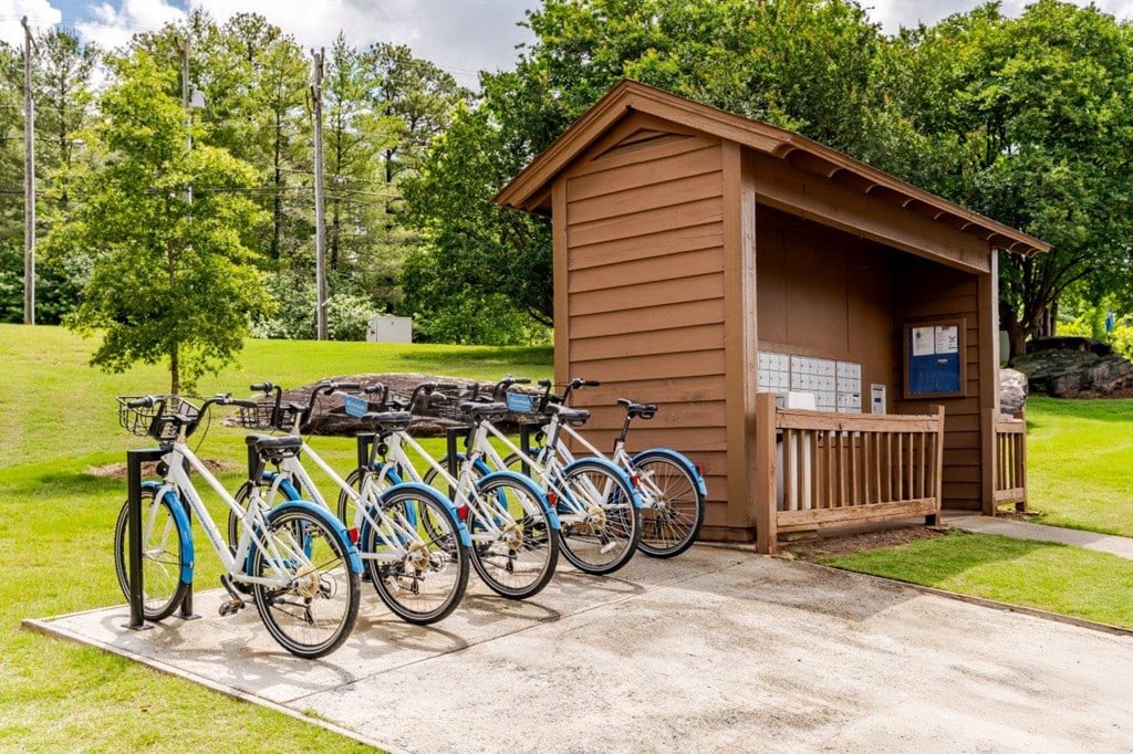A row of bicycles are parked in front of a small wooden building.