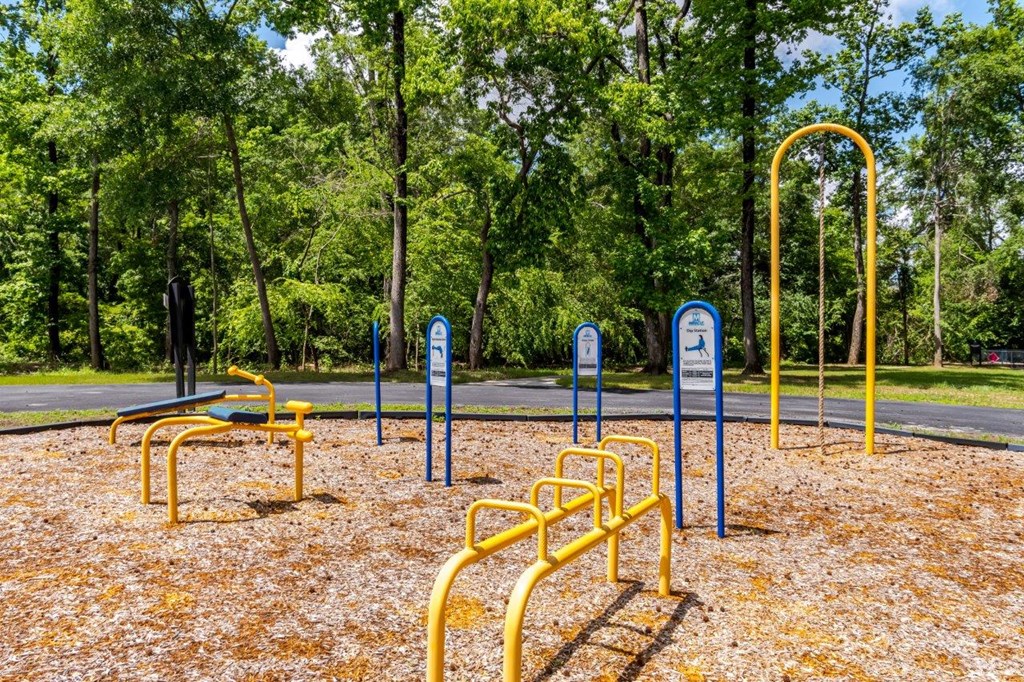 A playground with yellow equipment and blue signs.