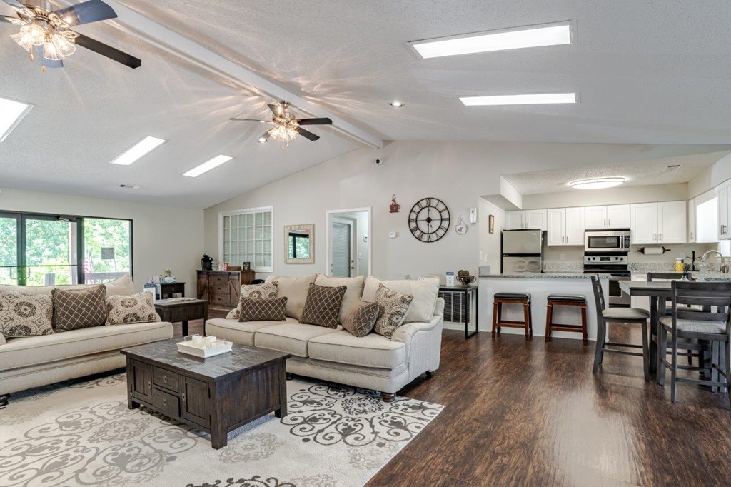 A spacious living room with a large sectional sofa and a coffee table in the center.