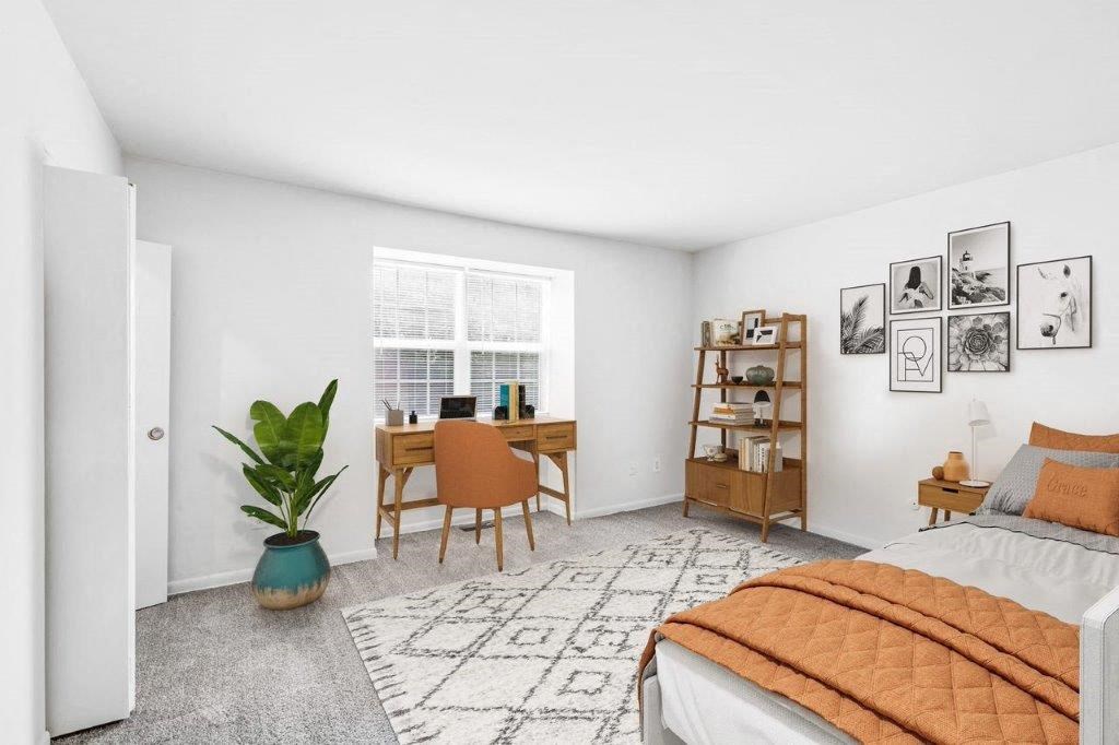 a bedroom with a bed and a desk and a window