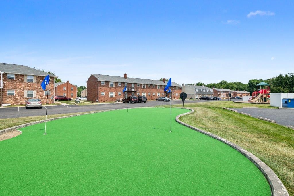 a putting green in front of a brick building