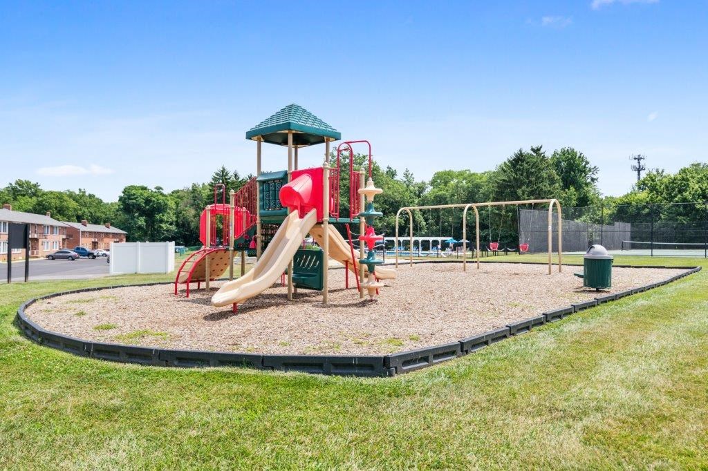 a playground with a swing set and slides in a park