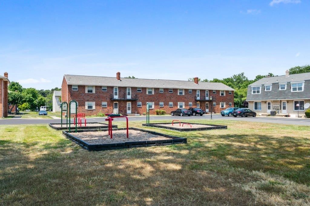a park with a playground in front of a brick building