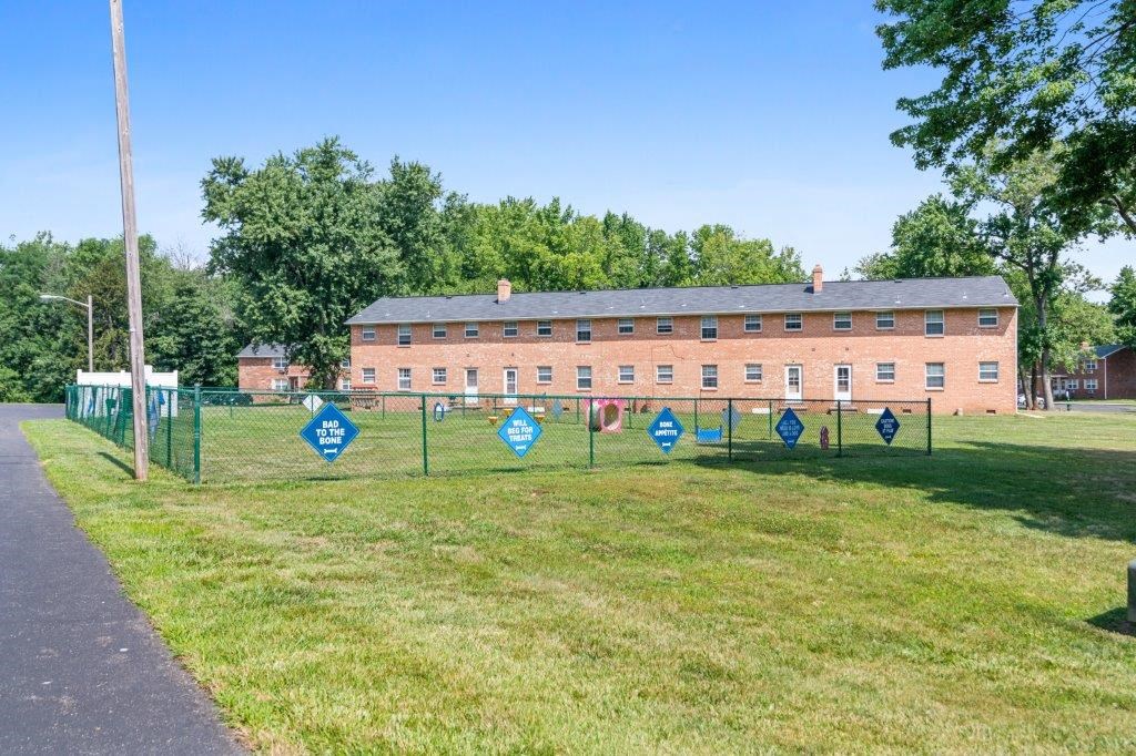 a large brick building with blue signs on a chain link fence