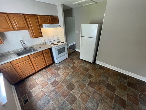 A kitchen with brown cabinets and a white stove top oven.
