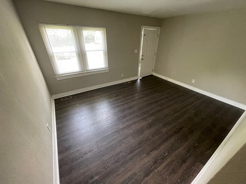 A room with a wooden floor and a window.