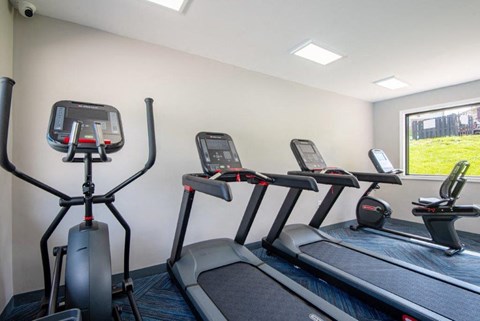 four treadmills in an exercise room with a window