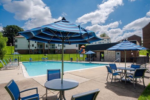 our apartments have a pool and patio with chairs and umbrellas