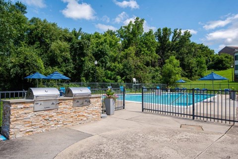 a swimming pool with a fence and barbecue grill