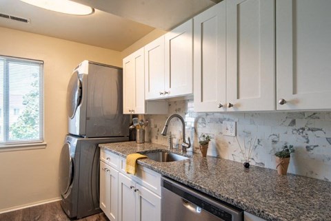 a kitchen with a granite counter top and a stainless steel refrigerator