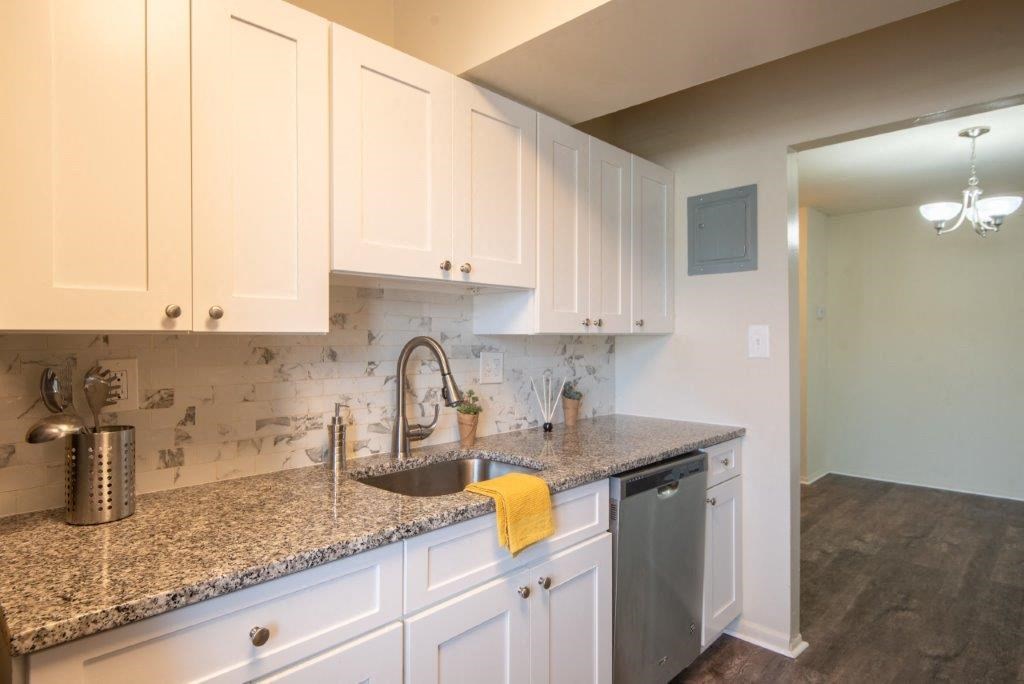 a kitchen with white cabinets and granite counter tops