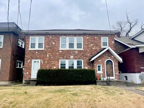 a brick house with a yard in front of it