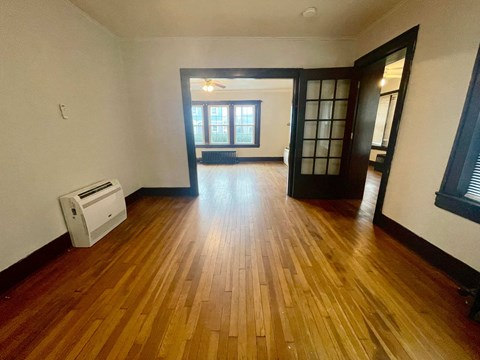 an empty living room with a hard wood floor and