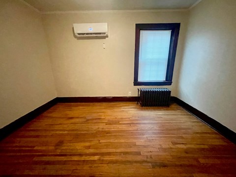an empty room with wooden floors and a window