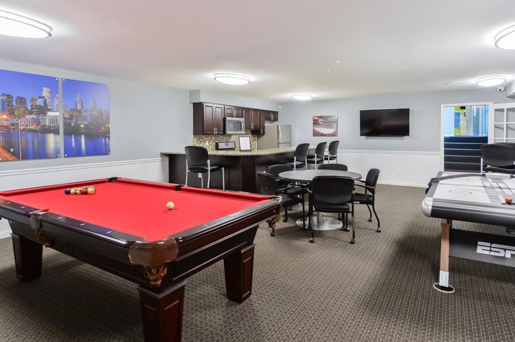 a games room with a pool table and a bar