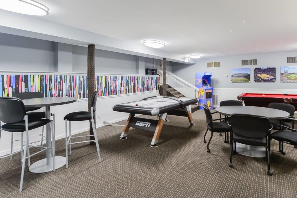 a game room with a pool table and tables