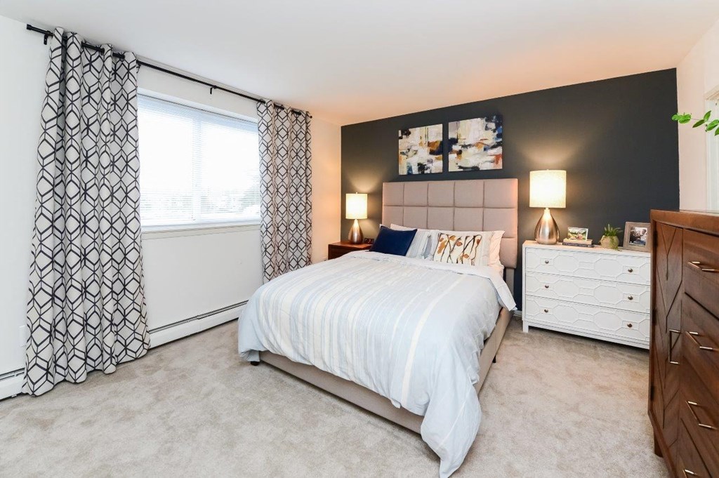 a bedroom with a bed and a window with curtains