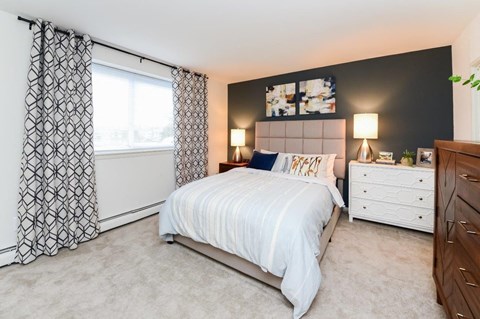 a bedroom with a bed and a window with curtains