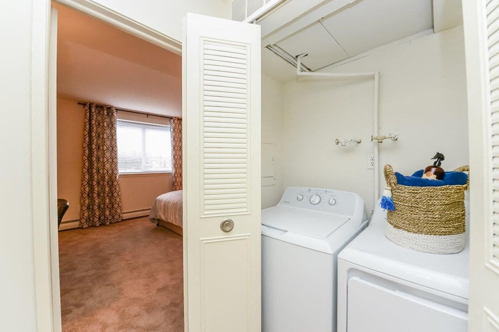 a laundry room with a washer and dryer and a bed