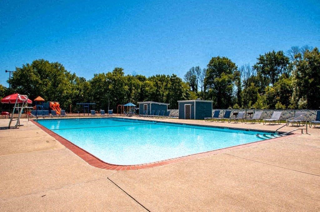 a swimming pool with trees in the background