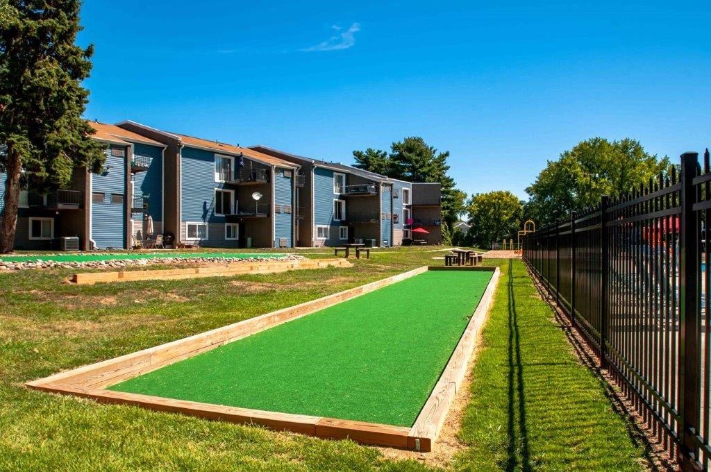 a mini golf course in front of a row of apartments
