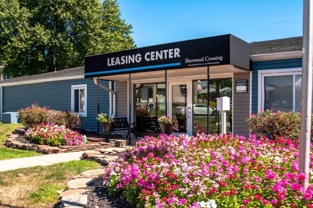 the building of leasing center with flowers in front of it