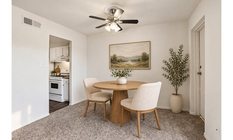 A dining room with a round table and chairs.