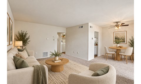 A living room with a couch, chairs, and a dining table.
