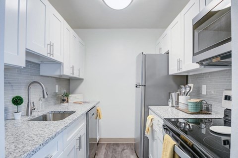 A kitchen with white cabinets and a black stove top oven.