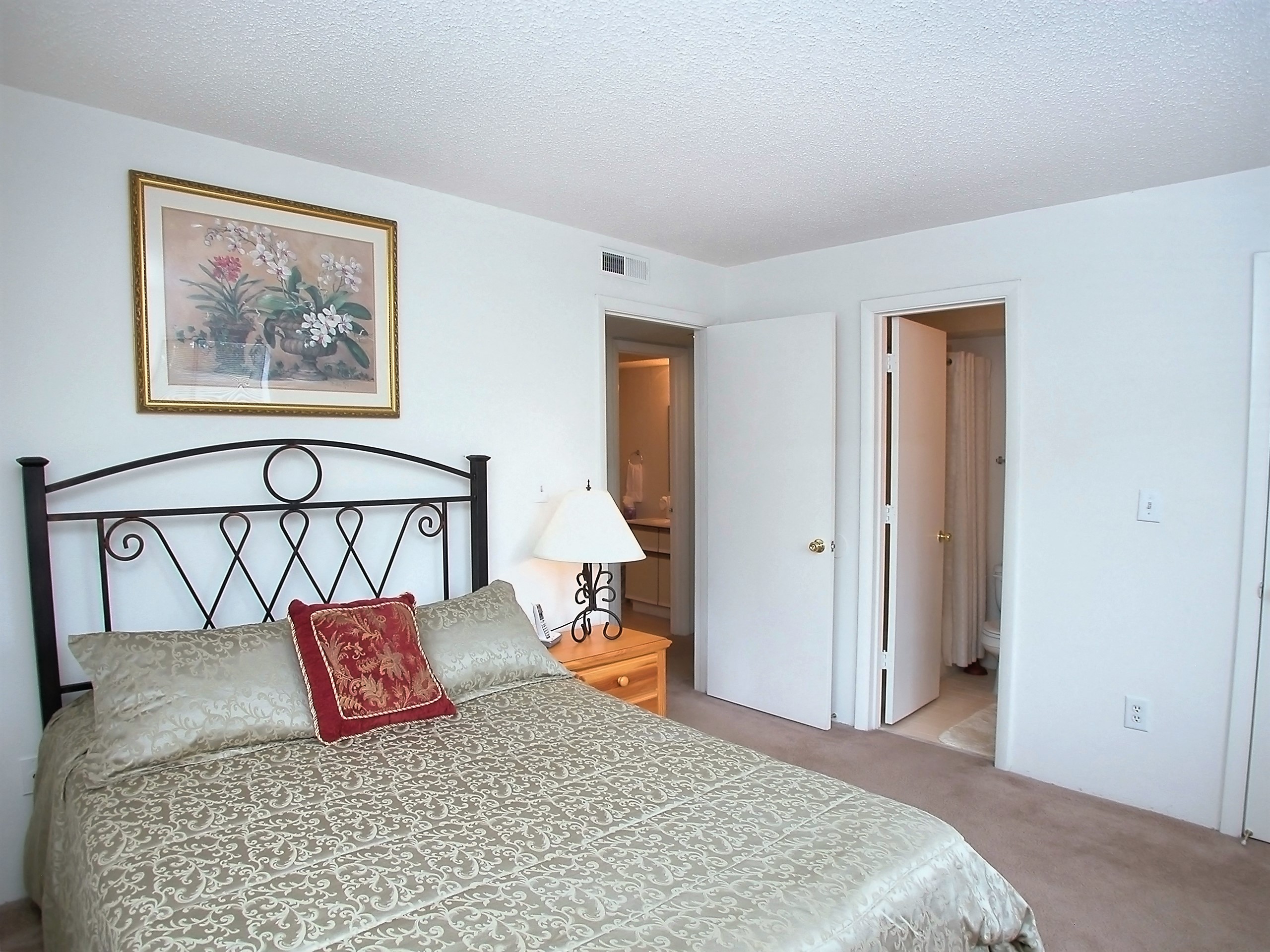 a bedroom with a bed and a door to a bathroom