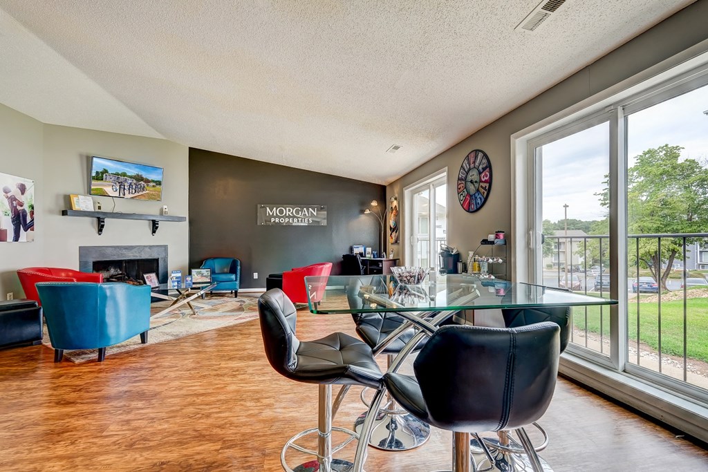 a living room with a glass table and chairs and a large window