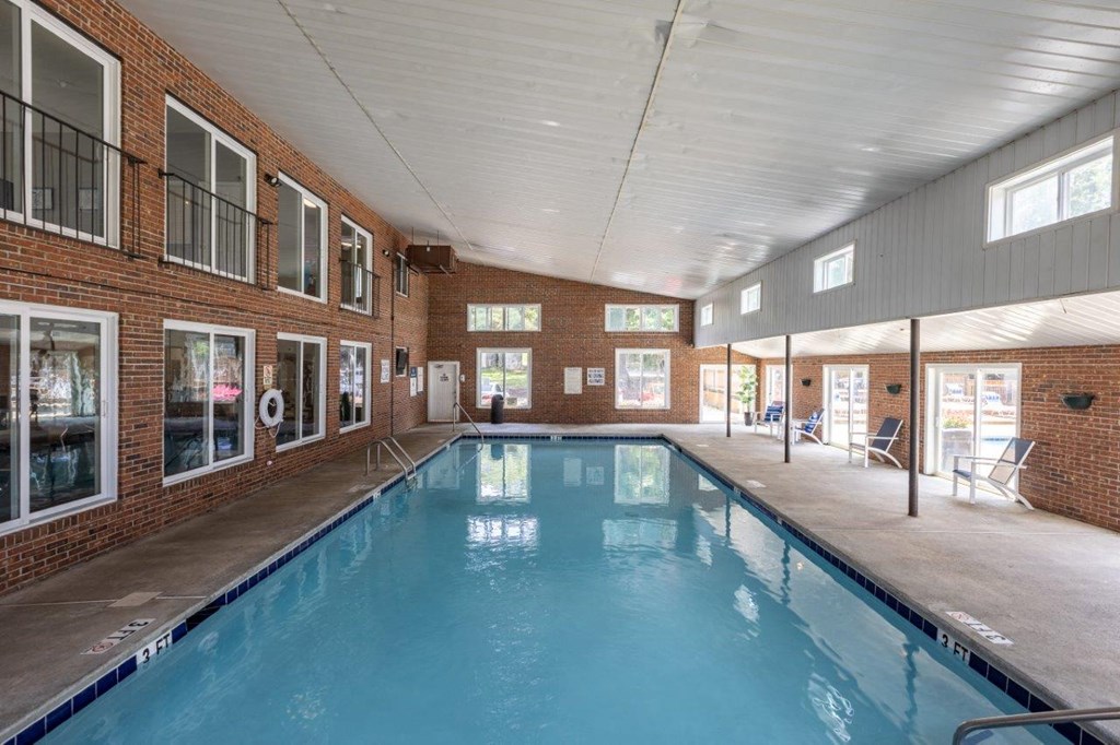 the indoor swimming pool is next to the windows of a brick building