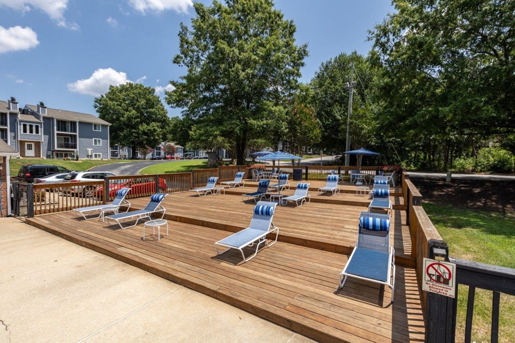 a large deck with chairs and benches overlooking the water
