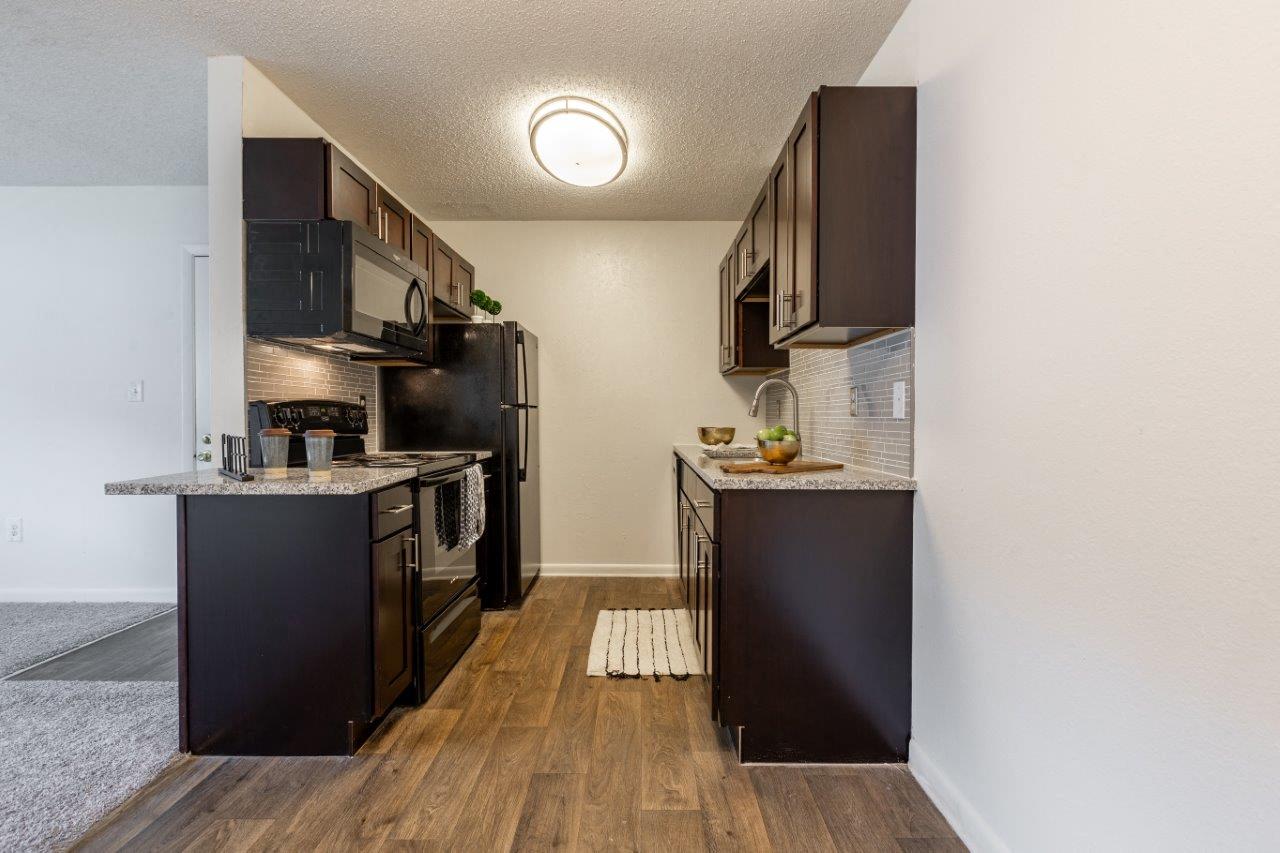 a kitchen with black appliances and a counter top and