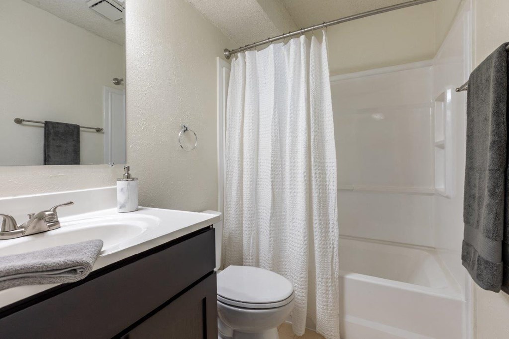 a bathroom with a shower and a sink and a toilet
