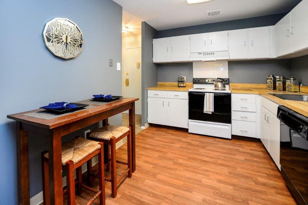 a kitchen with white cabinets and a wooden table