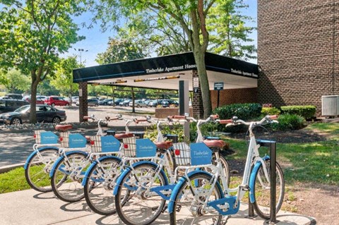 a row of blue bikes parked in front of a building