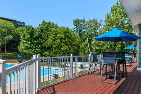 a deck with a pool and a table and umbrella