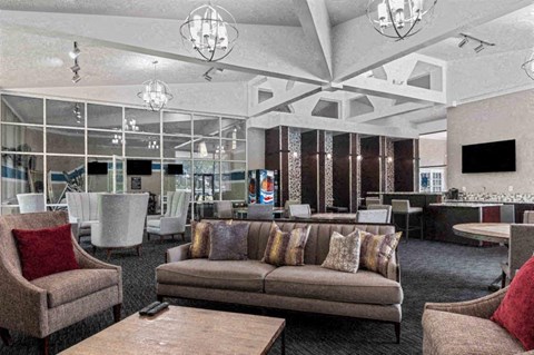 a lounge room with couches and chairs and a tv