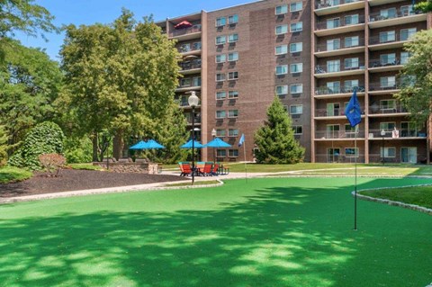 a park with a green lawn in front of an apartment building