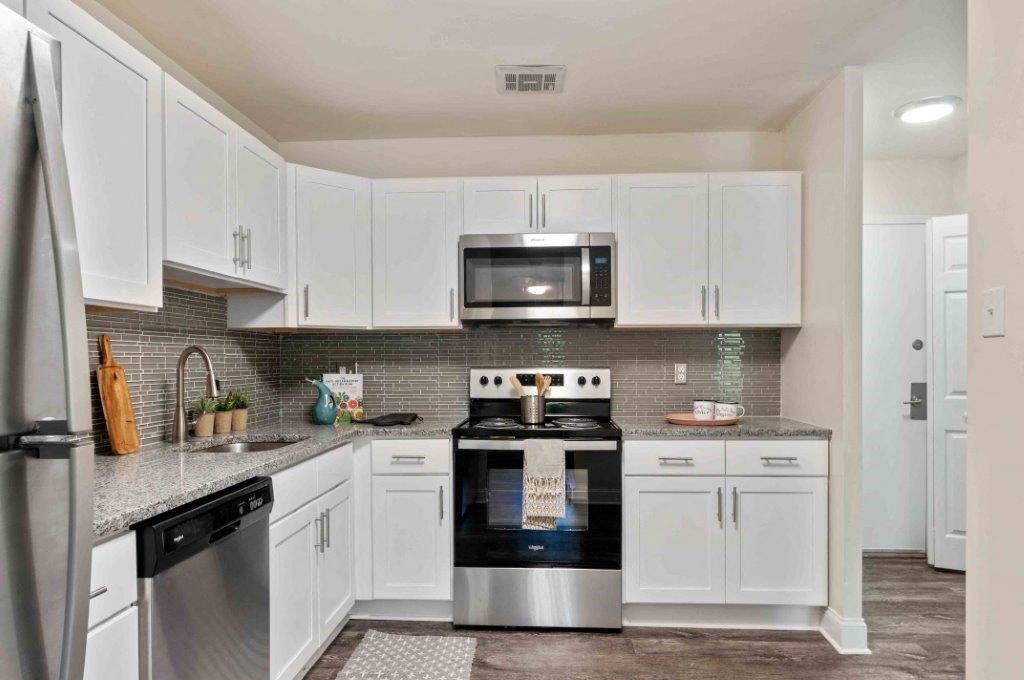 a kitchen with white cabinets and a stove and a microwave